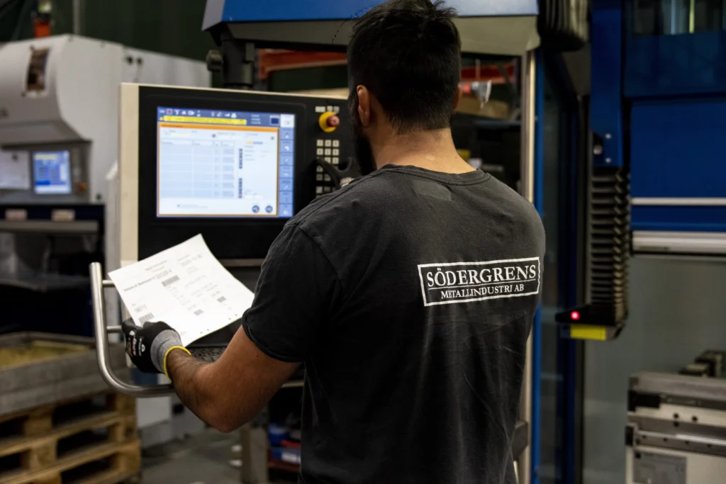 viärsodergrens Person bakifrån som står framför en maskin och kollar in i en skärm