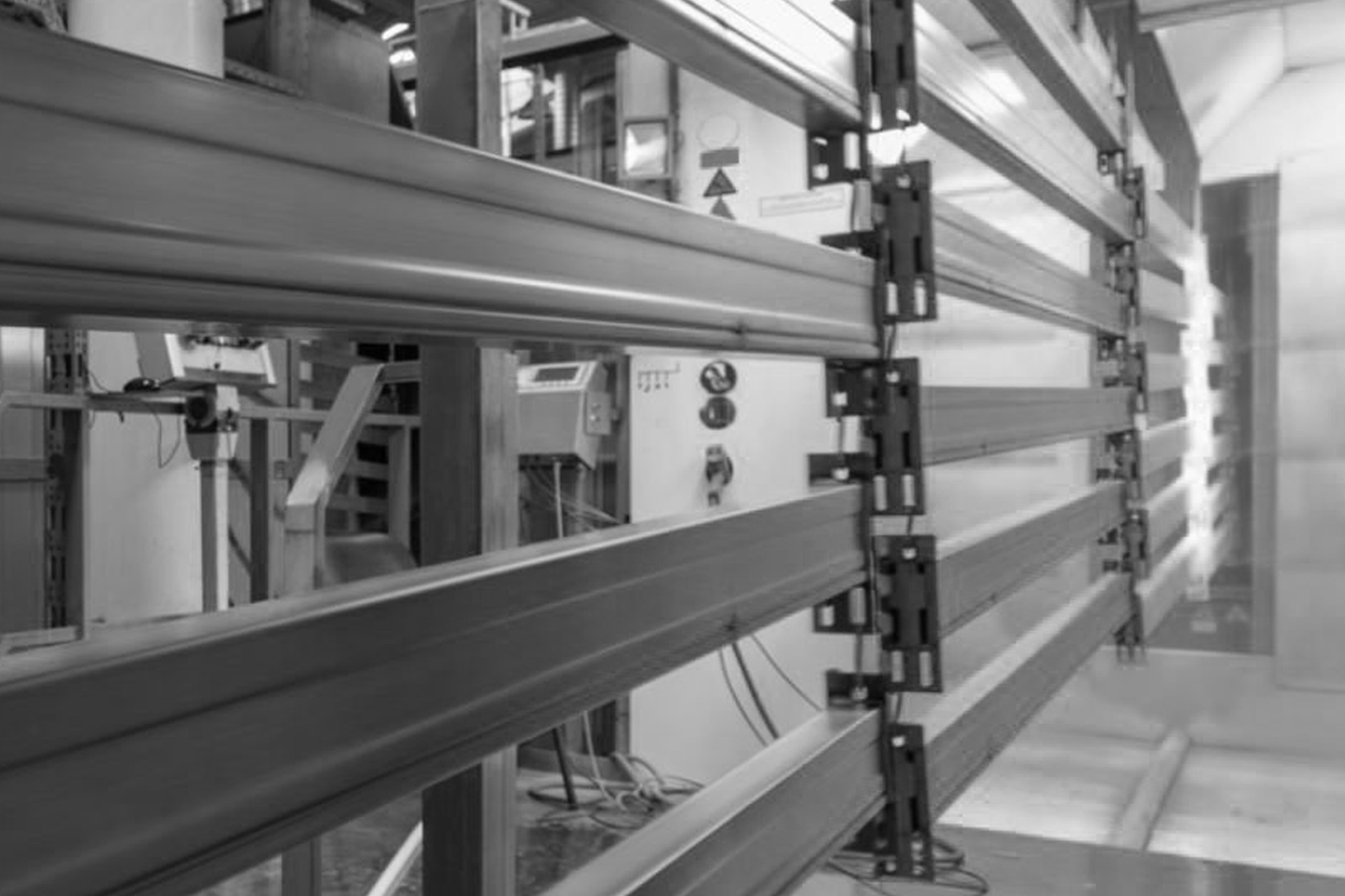 balkar som pulverlackeras med robotarmar.